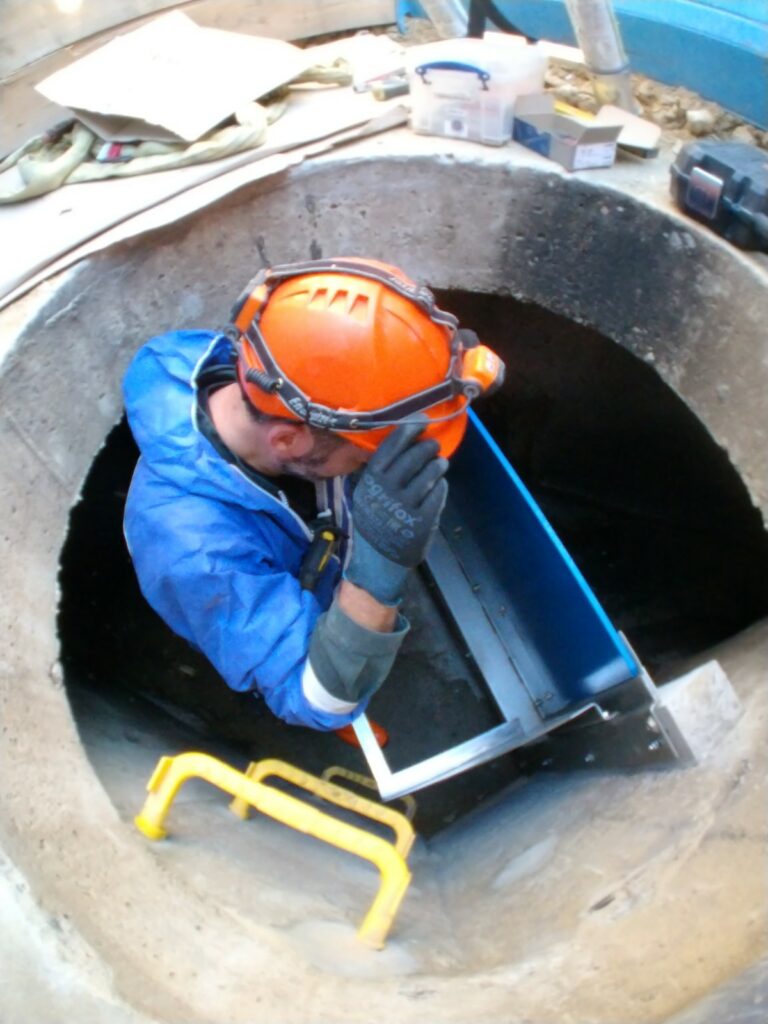 Le chaudronnier de 3D EAU descend les éléments constitutifs de la vanne hydrodynamique par le regard d'accès